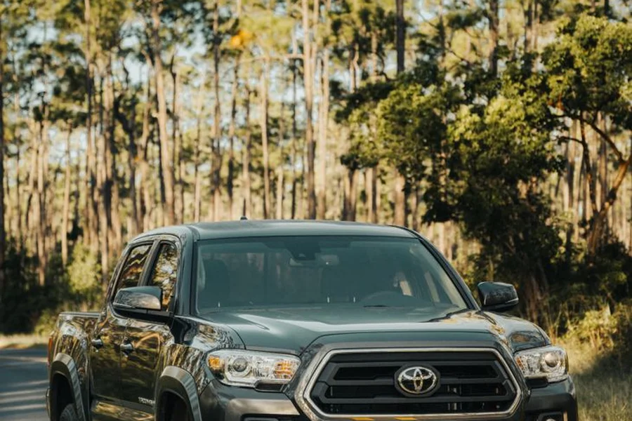 Chevy Hillsboro Oregon: Dealerships, Models & Service Guide Modern pickup truck driving on highway through Pacific Northwest forest