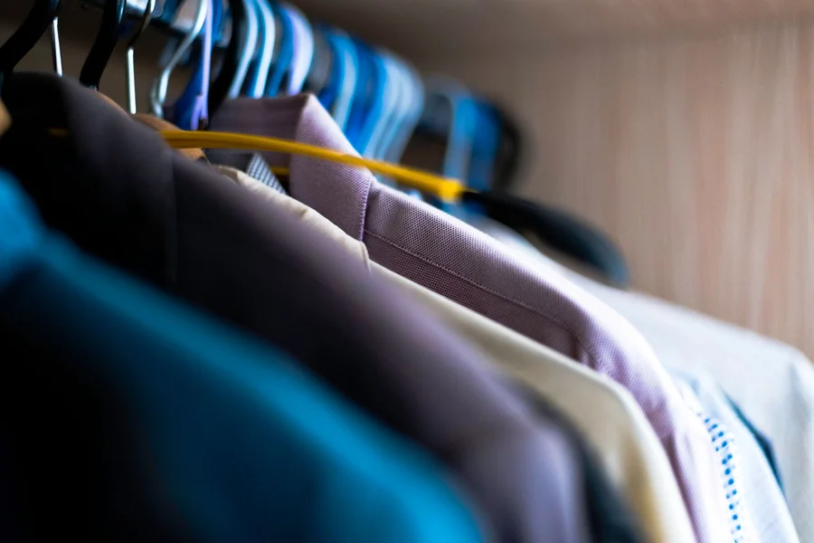 Neatly arranged wardrobe with pressed shirts and blazers