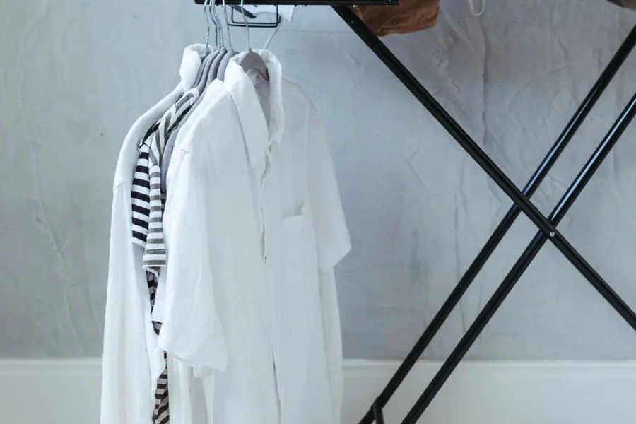 Traditional iron on ironing board with clean cotton shirt