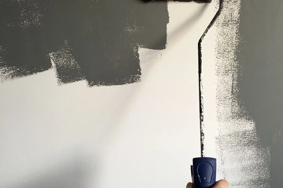 Homeowner using a foam roller and brush during a DIY countertop refinishing project