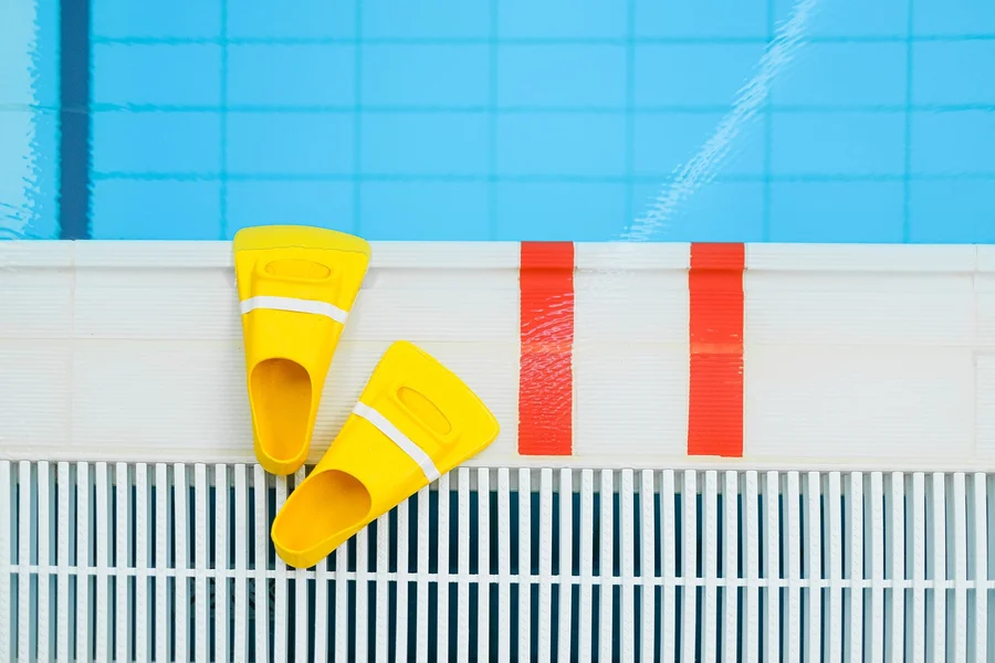Pool water chemical testing kit sitting on a sunlit pool deck